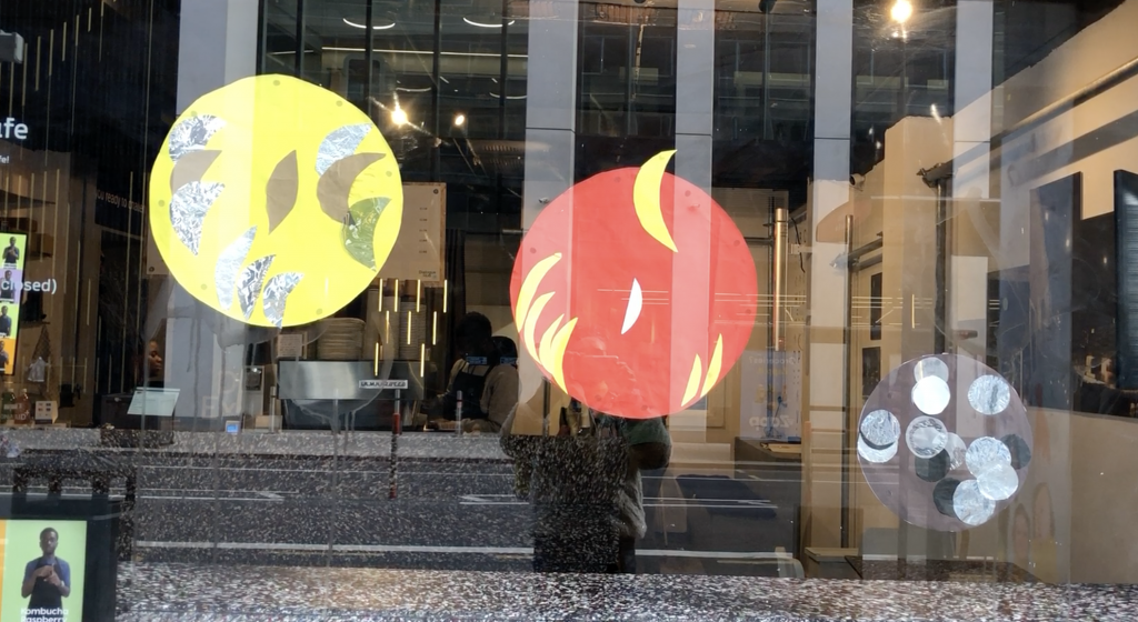 collages of yellow, orange and brown multiple moons within lager lunar outlines - shown on the front of the Dialogue Hub Cafe